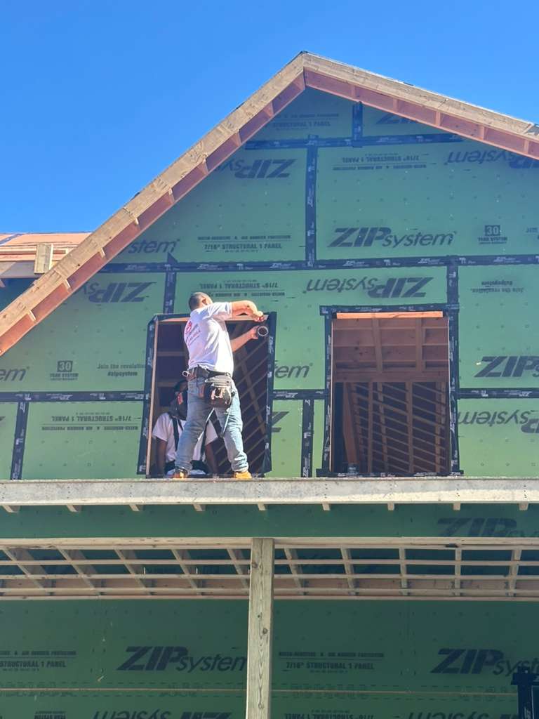 Carpenters installing a window in a ZIP System wall in Massachusetts