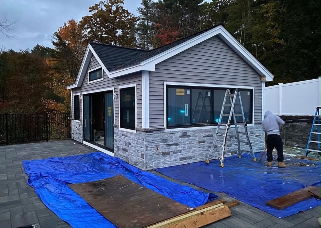 The same pool house after siding, stone veneer and window installation